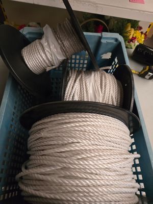 un panier rempli de corde blanche et d'une paire de ciseaux