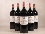 quatre bouteilles de vin rouge sont alignées sur une table