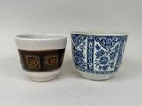 two cups that are sitting side by side on a table