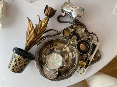a white table topped with a bowl of silver and gold items