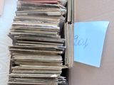 une boîte en carton remplie de vieux disques posée sur un lit