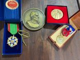 une médaille d'or posée sur une table en bois, à côté d'autres médailles