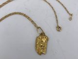 a gold lion head pendant on a gold chain