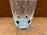 un verre orné d'un visage, posé sur une table