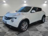the white nissan juke suv is parked on a checkered floor