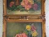 two paintings of flowers are hanging on a wall in a room