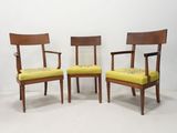 deux chaises en bois avec des coussins rembourrés jaunes dans une pièce blanche