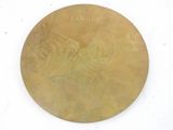 a gold medal on a white surface with writing on it
