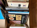 de nombreux livres empilés les uns sur les autres dans une boîte en carton