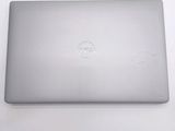 dell laptop computer sitting on a white surface with a logo on the screen