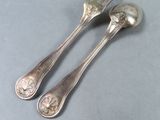 two spoons that are sitting next to each other on a table
