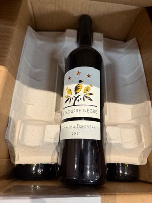 une bouteille de vin posée sur une table dans un coffret