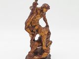 a bronze figurine of a man on a rock holding a bird