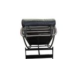the black leather chair is sitting on a metal stand