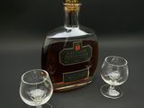 une bouteille d'alcool et deux verres posés sur une table