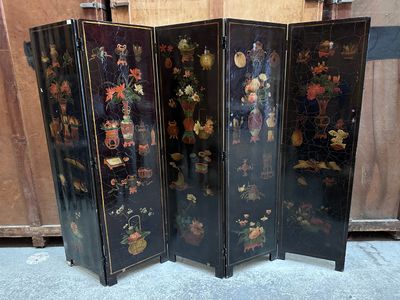a black room divider with a bunch of flowers on it