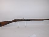 un fusil avec un canon en bois sur une surface blanche