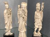 trois figurines chinoises sculptées représentant des hommes et des femmes, exposées