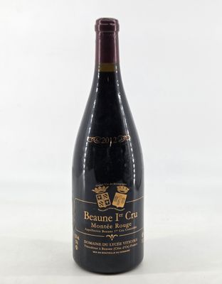 a bottle of red wine sitting on top of a white table