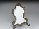un miroir ancien avec un cadre doré, posé sur un pied