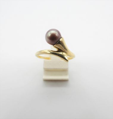 un gros plan d'une bague ornée d'une perle violette