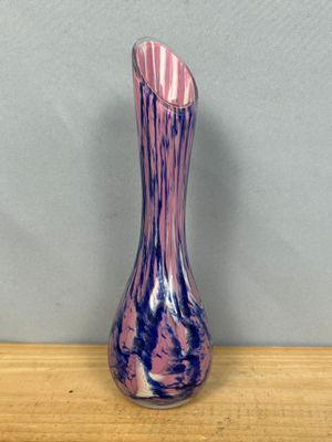 a purple and blue vase sitting on a wooden table