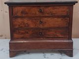 une petite commode en bois posée sur une table