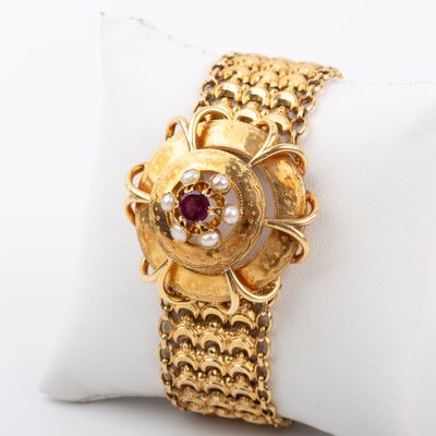 an image of a close up of a gold bracelet on a white pillow