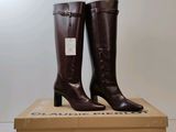 une paire de bottes marron posée sur une boîte en carton