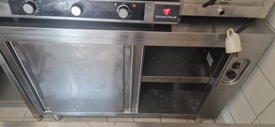 a stainless steel oven in a kitchen with a tile floor