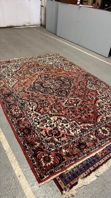 un tapis posé à même le sol dans une pièce aux murs blancs