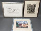 three framed pictures of a house and a house on a table