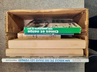 une pile de livres posée sur une boîte en carton