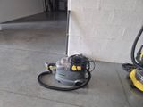 a yellow and black vacuum on the floor next to a yellow and black vacuum