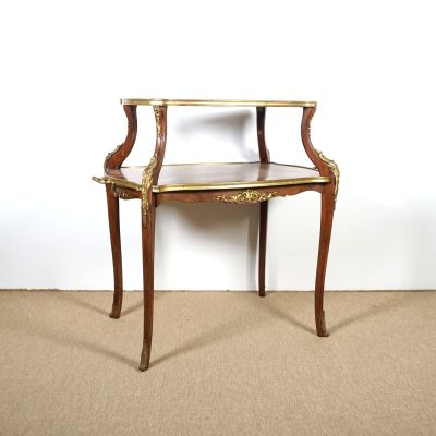 une petite table en bois avec un plateau en verre, posée sur un sol recouvert de moquette