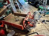 a red box with tools in it sitting on a wooden floor