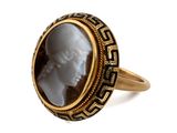 a close up of a gold ring with a white face in it