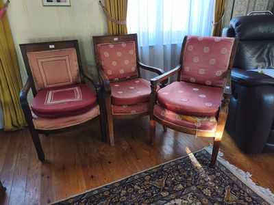 trois fauteuils dans un salon avec un tapis au sol