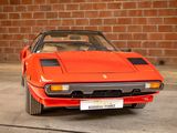 a red sports car parked in front of a brick wall