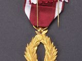 the medal is placed on a black surface with a red and white ribbon
