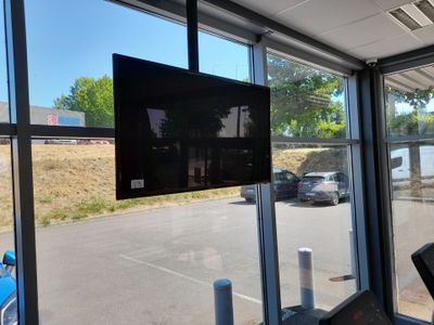 un téléviseur fixé au mur dans une salle de sport
