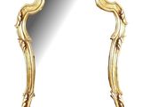 un miroir à cadre doré, orné d'un motif décoratif sur fond blanc