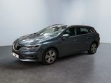 Une voiture grise est garée dans une pièce aux murs blancs