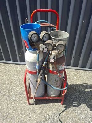 a red cart with two cylinders and a blue bucket on it