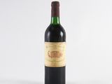 an old bottle of wine sitting on top of a white table