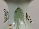 a vase with a painting on it sitting on a table