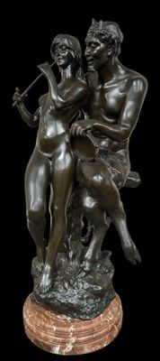 an image of a bronze statue of two women sitting on a rock