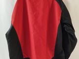 the back of a red and black jacket hanging on a white wall