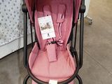 a baby stroller with a pink seat in a store