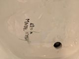 a white toilet with a black lid and a sticker on it